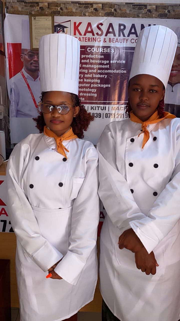 A young trainee in a chef hat smiling
